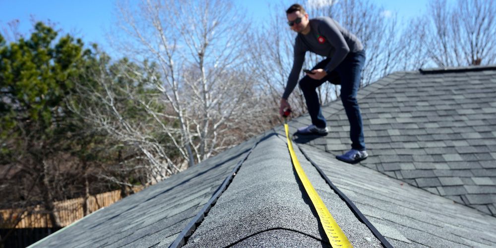 A man measuring the roof