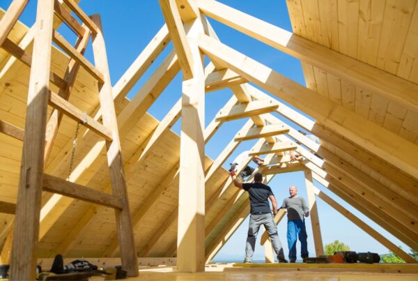 Two men working on roof braces.