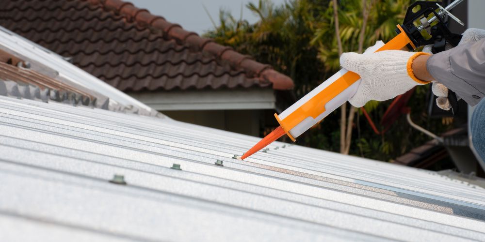 A man holding sealant for applying to a roof.