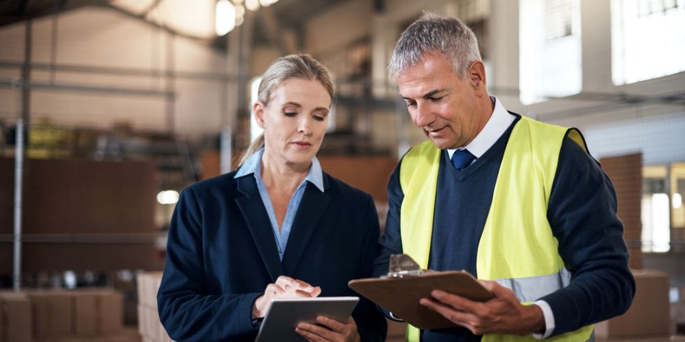 A woman and a man holding a checklist.